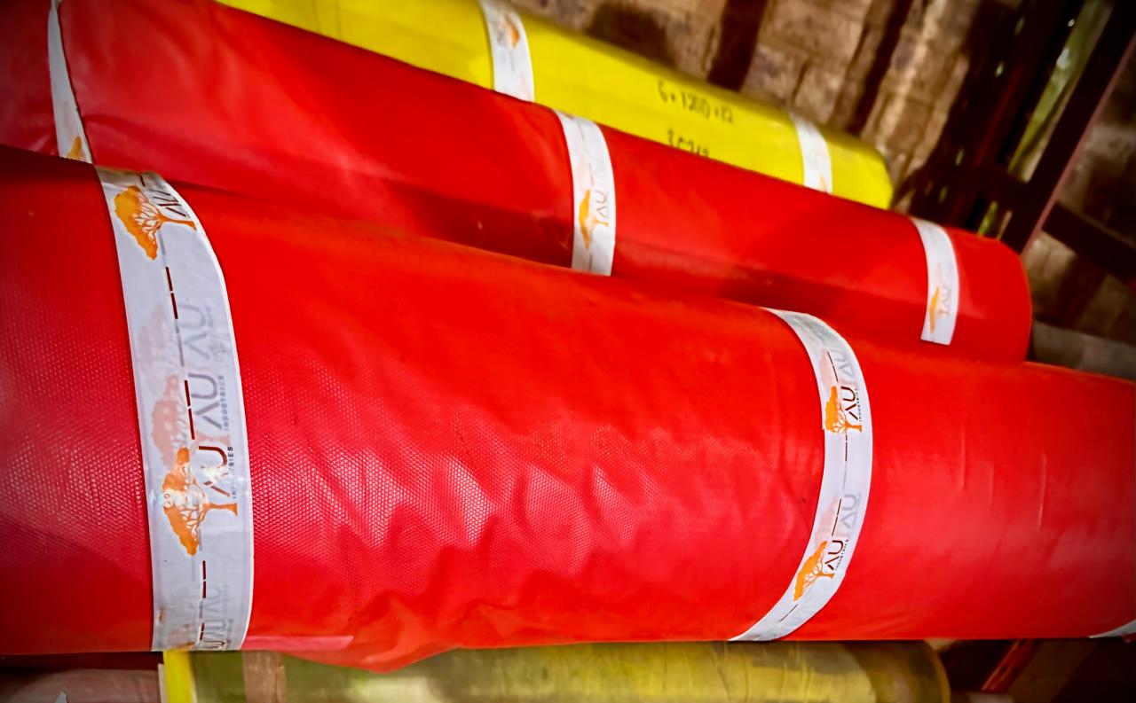 Stacked rubber sheeting rolls in AU Industries warehouse